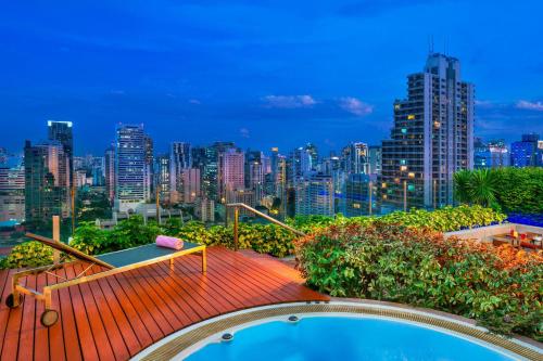 een zwembad en uitzicht op de skyline van de stad bij Aloft Bangkok - Sukhumvit 11 in Bangkok