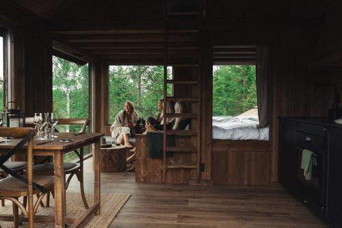 2 personas sentadas en una habitación con litera en Hyssna Forest Resort, en Hyssna