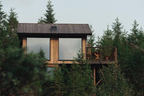 uma casa na árvore com um deque na floresta em Hyssna Forest Resort em Hyssna