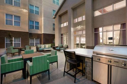 a restaurant with a bar and tables and chairs at Homewood Suites by Hilton Dallas-Arlington in Arlington