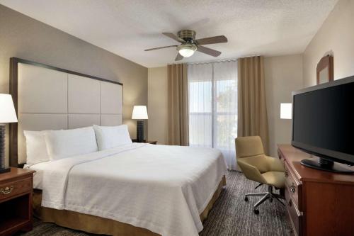 a hotel room with a bed and a flat screen tv at Homewood Suites by Hilton Dallas-Arlington in Arlington