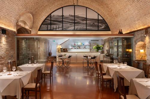Hotel Ristorante Borgo Antico في مونتيروني دي اربيا: مطعم فيه طاولات وكراسي في الغرفة
