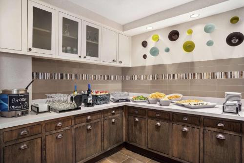 a kitchen with wooden cabinets and food on the counter at Homewood Suites by Hilton Phoenix-Chandler in Chandler