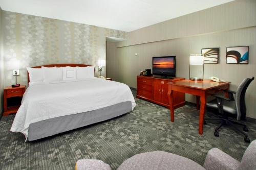 a hotel room with a bed and a desk and a television at Courtyard by Marriott Lyndhurst/Meadowlands in Lyndhurst