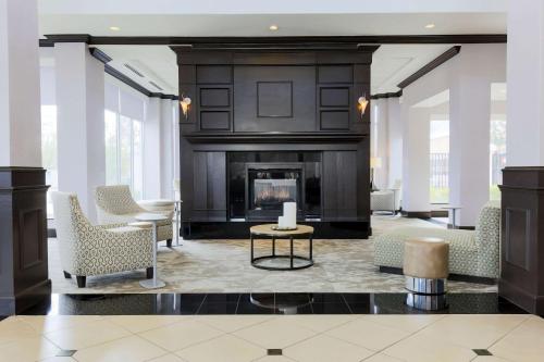 a living room with a fireplace and chairs at Hilton Garden Inn Norman in Norman