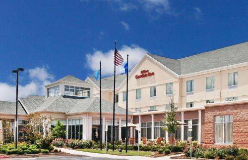 an exterior view of a hotel with an american flag at Hilton Garden Inn Norman in Norman