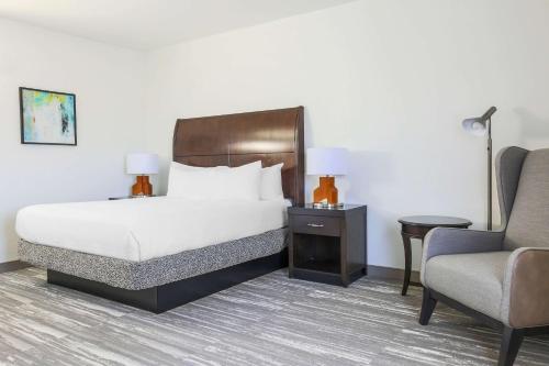 a hotel room with a bed and a chair at Hilton Garden Inn Norman in Norman