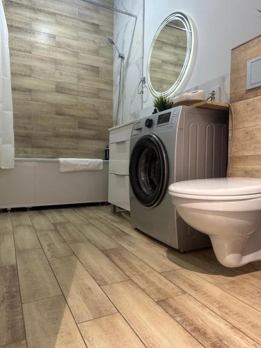uma casa de banho com uma máquina de lavar roupa e um WC em Уютная и комфортная 3х комнатная квартира со всеми условиями em Oral