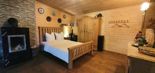 ein Schlafzimmer mit einem Bett in einem Zimmer mit Holzwänden in der Unterkunft Sauna2relax in Šveicarija