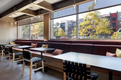 a row of tables and chairs in a restaurant with windows at Tru By Hilton Atlanta Galleria Ballpark, GA in Atlanta
