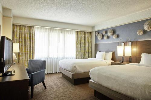 a hotel room with two beds and a television at Embassy Suites by Hilton Atlanta Galleria in Atlanta
