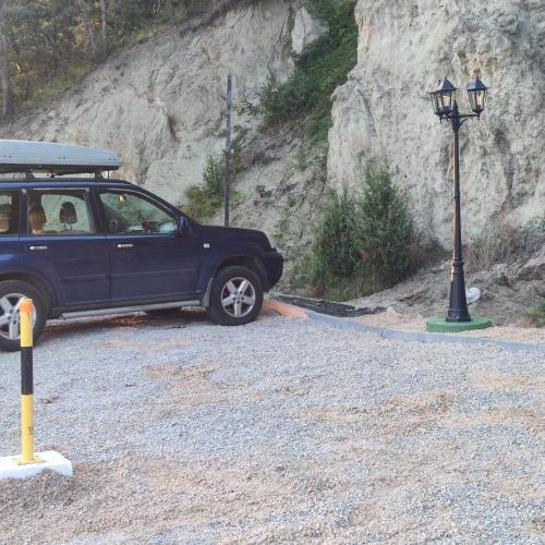 a blue car parked next to a street light at Seoski Turizam Feniks - apartman Ostrog in Kosjerić