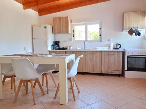 uma cozinha com uma mesa e cadeiras e um frigorífico em Country house Pantelatos em Pouláta