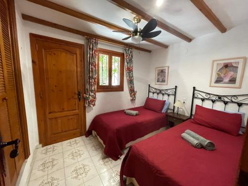 1 Schlafzimmer mit 2 Betten und einem Deckenventilator in der Unterkunft Villa GAN EDEN in La Drova