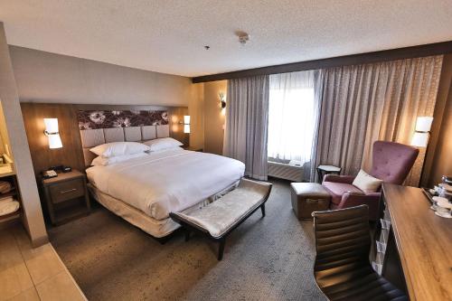 a hotel room with a bed and a chair at DoubleTree by Hilton Atlanta Alpharetta-Windward in Alpharetta