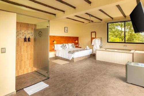 a bedroom with a bed and a shower and a tub at Hotel Alto de Pajas Boutique by H&R in Villeta