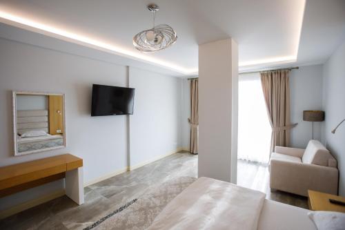 a bedroom with a bed and a couch and a tv at Hotel GRINT in Golem