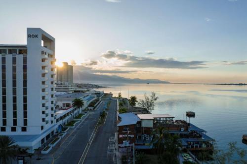 a view of a city with the sun setting over the water at ROK Hotel Kingston Tapestry Collection By Hilton in Kingston
