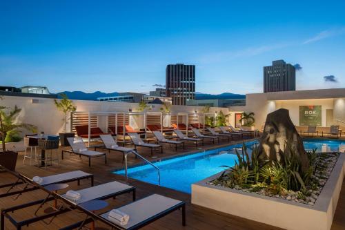 a hotel with a pool and lounge chairs at ROK Hotel Kingston Tapestry Collection By Hilton in Kingston