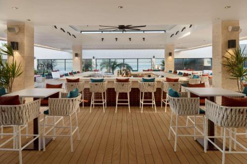 a restaurant with tables and chairs and a bar at ROK Hotel Kingston Tapestry Collection By Hilton in Kingston