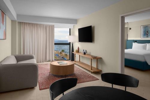a hotel room with a bed and a living room at ROK Hotel Kingston Tapestry Collection By Hilton in Kingston