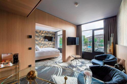 a hotel room with a bed and a living room at Apollo Hotel Amsterdam, a Tribute Portfolio Hotel in Amsterdam
