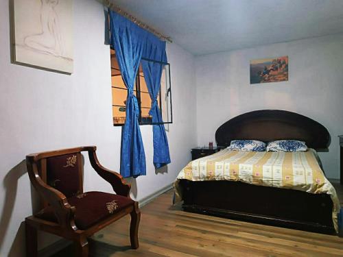 キトにあるLindo Departamento amoblado en el Centro de Quitoのベッドルーム1室(ベッド1台、椅子付)