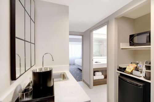 kuchnia z umywalką oraz łazienka z łóżkiem w obiekcie Embassy Suites by Hilton Atlanta Perimeter Center w Atlancie