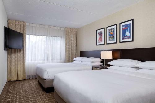 a hotel room with two beds and a flat screen tv at DoubleTree Suites by Hilton Nashville Airport in Nashville