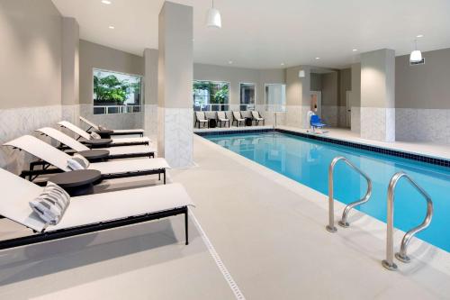 a pool with lounge chairs next to a swimming pool at Embassy Suites by Hilton San Rafael Marin County in San Rafael