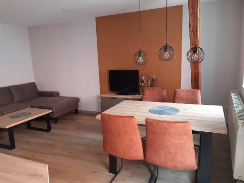 een eetkamer met een tafel en stoelen en een bank bij Weingut Engelhardt in Röttingen