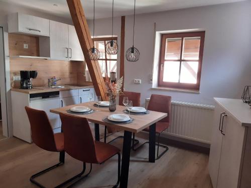 a kitchen with a wooden table with chairs and a dining room at Weingut Engelhardt in Röttingen
