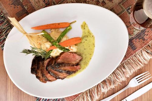 a plate of food with meat and vegetables on a table at Embassy Suites by Hilton Phoenix Downtown North in Phoenix