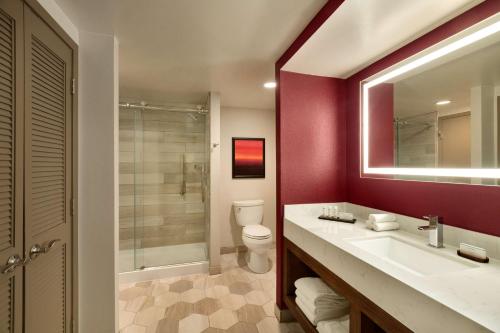 a bathroom with a sink and a toilet and a mirror at Embassy Suites by Hilton Phoenix Downtown North in Phoenix