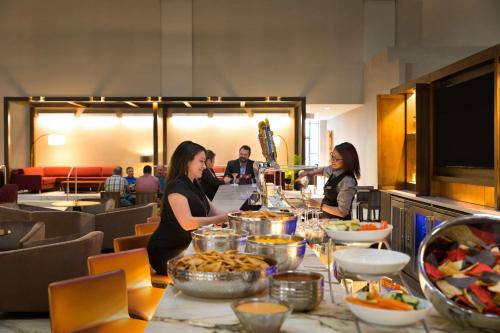 a group of people standing around a table with food at Embassy Suites by Hilton Phoenix Downtown North in Phoenix