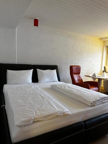 a bedroom with a bed and a red chair at Appartementhaus Birkenwald in Seefeld in Tirol