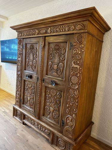 a large wooden cabinet is against a wall at Appartementhaus Birkenwald in Seefeld in Tirol