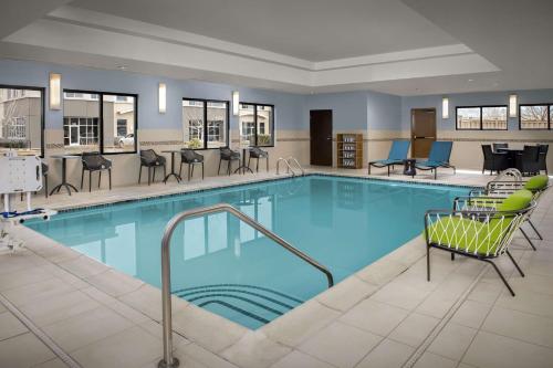 una gran piscina con sillas y mesas en Hampton Inn & Suites Portland/Hillsboro-Evergreen Park, en Hillsboro