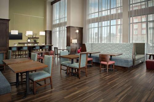a restaurant with tables and chairs and windows at Hampton Inn & Suites Portland/Hillsboro-Evergreen Park in Hillsboro