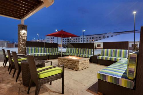 a rooftop patio with chairs and tables and a fire pit at Home2 Suites by Hilton Anchorage/Midtown in Anchorage