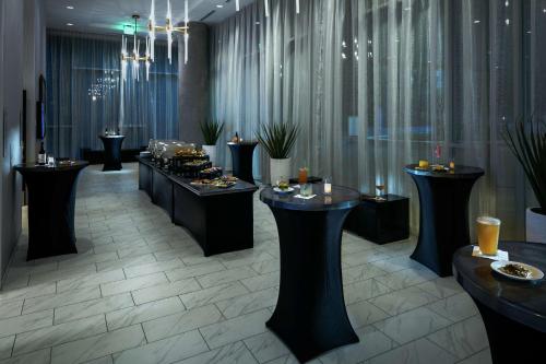 a restaurant with black tables with food on them at Hilton Garden Inn Seattle Bellevue Downtown, WA in Bellevue