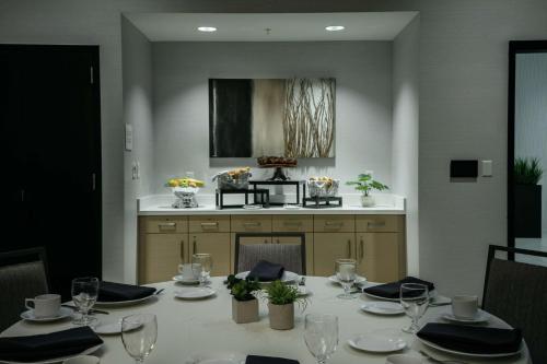 a dining room table with a white table cloth and glasses at Hilton Garden Inn Seattle Bellevue Downtown, WA in Bellevue