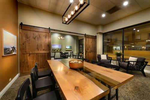 a dining room with a wooden table and chairs at Hotel Maison Yakima Tapestry Collection by Hilton in Yakima