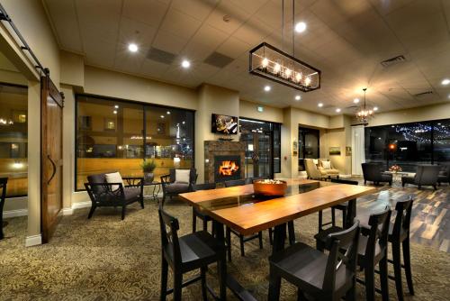 a dining room with a table and chairs and a fireplace at Hotel Maison Yakima Tapestry Collection by Hilton in Yakima
