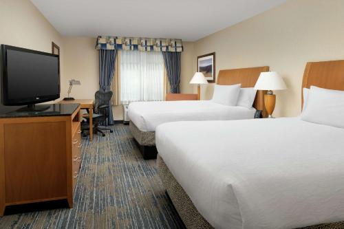 a hotel room with two beds and a flat screen tv at Hilton Garden Inn Yakima Downtown in Yakima