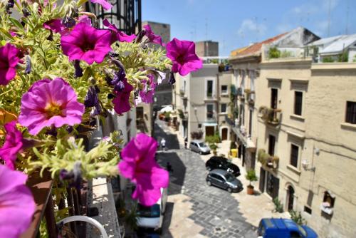 a view of a city street with purple flowers on a balcony at The Cathedral House in Bari