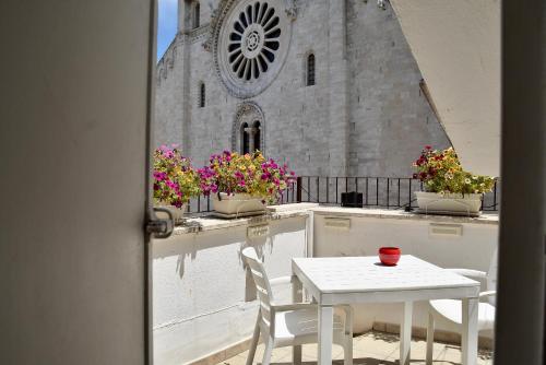 a table and chairs on a balcony in front of a church at The Cathedral House in Bari