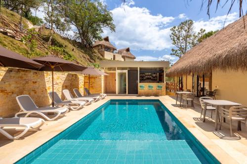 a villa with a swimming pool and chairs and a house at Hotel Alto de Pajas Boutique by H&R in Villeta
