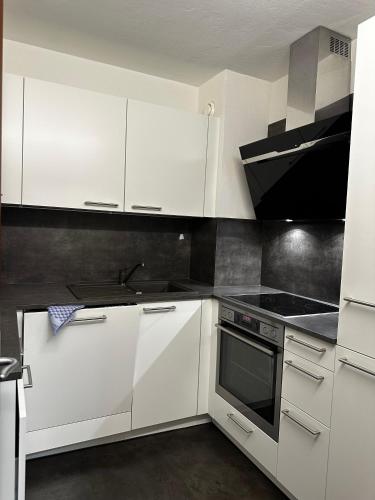 a kitchen with white cabinets and a stove top oven at Appartementhaus Birkenwald in Seefeld in Tirol