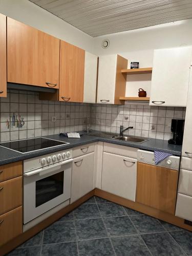 a kitchen with white appliances and wooden cabinets at Appartementhaus Birkenwald in Seefeld in Tirol